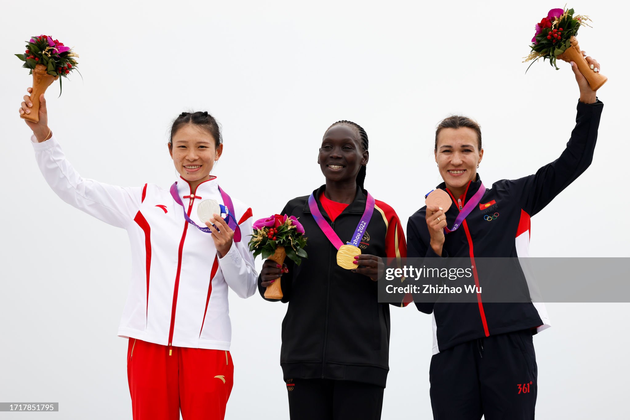 HANGZHOU, CHINA - OCTOBER 05: Gold medallist Eunice Chebichii Paul Chumba (C) of Bahrain, Silver medallist Zhang Deshun of China, Bronze medallist Sardana Trofimova of Kyrgyzstan attend the award ceremony after the 19th Asian Game Women's Marathon Final at Smart New World Qiantang River Green Belt on October 05, 2023 in Hangzhou, China. (Photo by Zhizhao Wu/Getty Images)